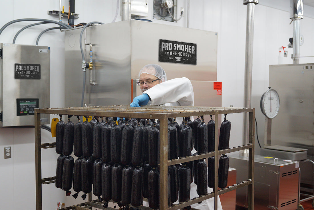 Chef inspecting commercial smoked summer sausage in casings Pro Smoker
